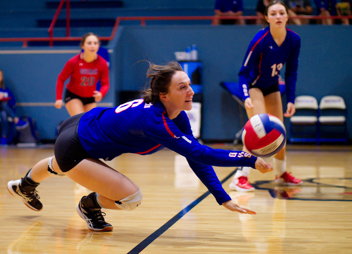 Peyton Kruckner lunges to dig out the low ball. [view more volleyball shots]